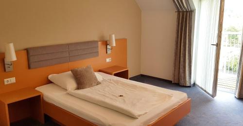 古森多夫福鲁克斯佩威特酒店的一间卧室设有一张大床和一个大窗户