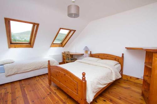 丁格尔Rainbow hostel的一间卧室设有两张床、一张桌子和窗户。