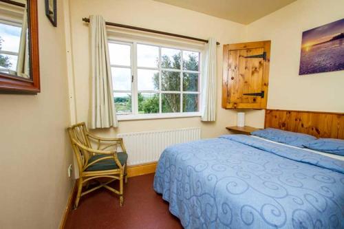 丁格尔Rainbow hostel的卧室配有床、椅子和窗户。
