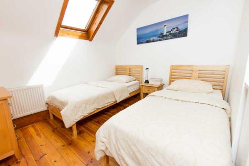 丁格尔Rainbow hostel的一间卧室设有两张床和窗户。