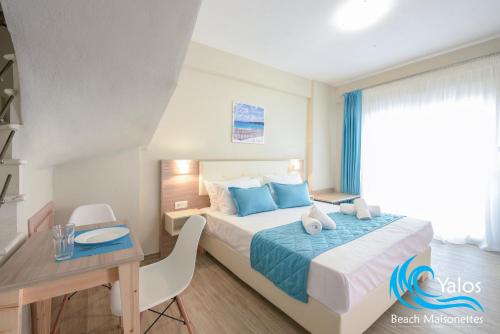 斯卡拉索提罗斯Yalos Beach Maisonettes的酒店客房配有一张床、一张书桌和一张书桌。