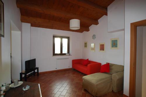 努马纳Casale Le Maschere的带沙发和红色椅子的客厅