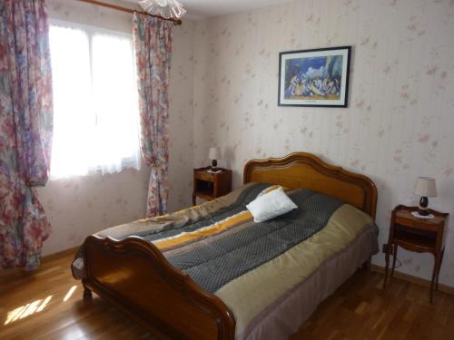 OrbignyLa maison des Bruyères的一间带床的卧室,位于带窗户的房间内