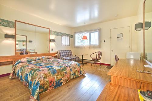 隆格伊R-100汽车旅馆的卧室配有1张床、1张桌子和1把椅子