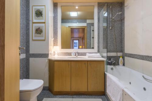 波尔图Deluxe Condominium with Ocean View的一间带水槽、浴缸和卫生间的浴室