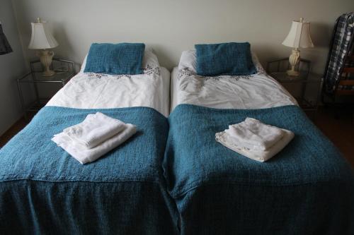 斯科加尔弗斯Fosstún Guesthouse的两张床并在一起,配有毛巾