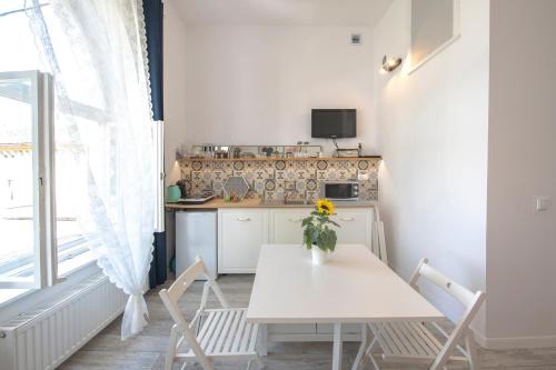 隆代克-兹德鲁伊Apartament Zamkowy的小厨房配有白色的桌子和椅子