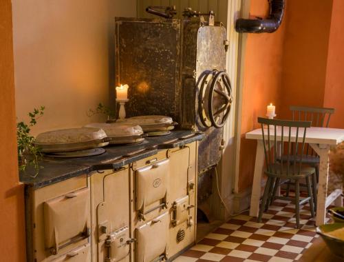 瓦克斯霍尔姆卡斯特雷特住宿加早餐酒店的旧炉子,带桌子和蜡烛的房间