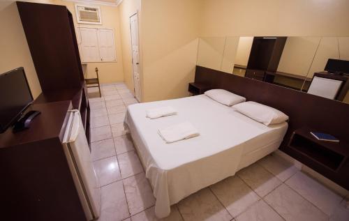 马卡帕Hotel Holliday的一间卧室配有一张床,上面有两条毛巾