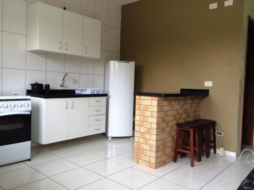 巴拉那州蓬塔尔Praia Sul Ipanema的厨房配有白色冰箱和砖砌壁炉