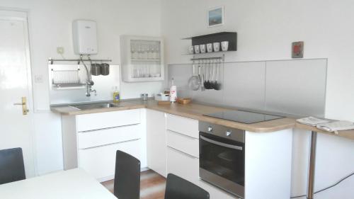 维斯Vila Rosa的厨房配有白色橱柜和台面