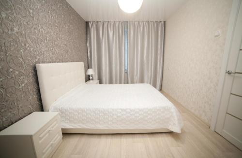 克拉斯诺亚尔斯克Alekseyeva Apartament的卧室配有白色的床和窗户。