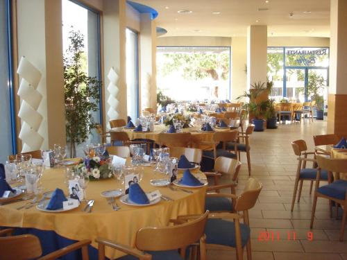 阿尔比尔罗伯特帕拉什酒店的一间配备有桌椅及蓝餐巾的用餐室
