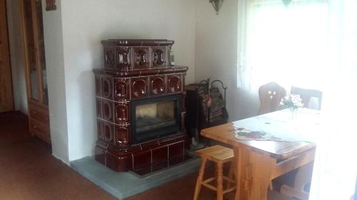 特鲁特诺夫Chata Dolce I的客厅配有燃木火炉和桌子