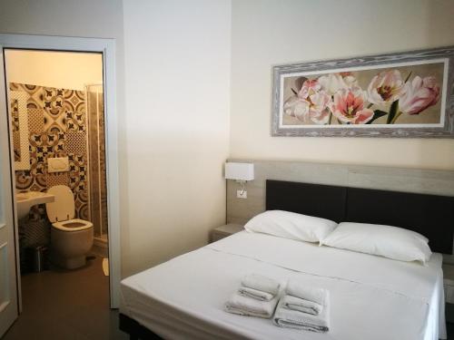罗马IL Sole的一间卧室配有一张床,上面有两条毛巾
