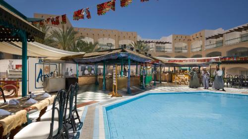 赫尔格达贝尔艾尔蓝色海岸度假酒店（仅限成人）的一座游泳池,里面的人站在四周