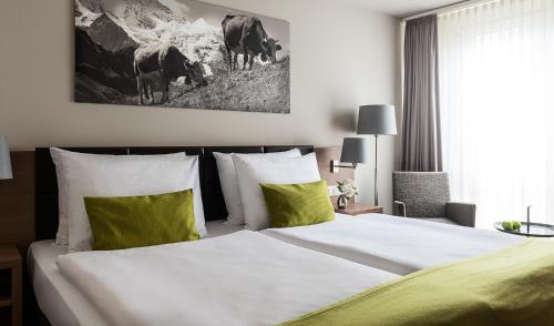 卢塞恩AMERON Luzern Hotel Flora的一间卧室配有一张带绿色和白色枕头的大床