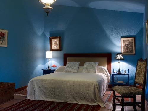 Valle de Guerra海赛达德瓦丽螺斯肯雅乡村民宿的蓝色卧室,配有床和两把椅子