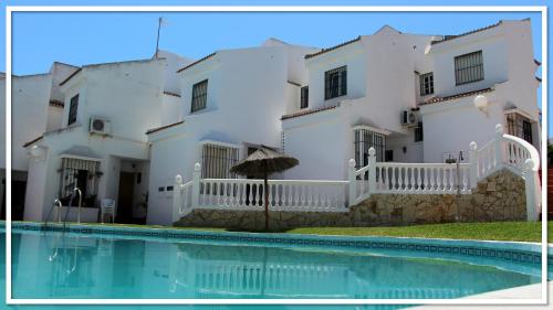 奇尔切斯Casa Las Toro Playa的一座白色的房子,前面设有一个游泳池