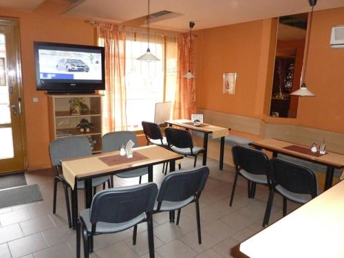 特热比奇维斯阿维斯旅馆的餐厅设有桌椅和平面电视。