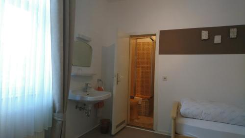 CobbenrodeGasthof zur Post的一间带水槽、床和镜子的浴室