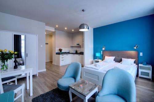 克拉科夫扎克瓦15公寓式酒店的蓝色卧室,配有床和两把蓝色椅子