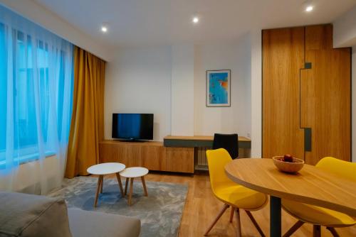 布加勒斯特Arbans Elegant apartment in the city center的客厅配有桌子和黄色椅子