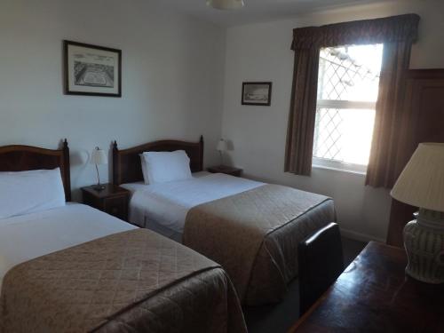 考文垂Ashleigh House的酒店客房设有两张床和窗户。