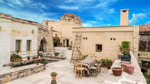 乌奇希萨尔Maze Of Cappadocia Hotel的大楼前带桌椅的天井