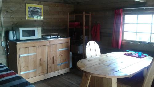 Boazumblokhut us Mem的厨房配有木桌和微波炉