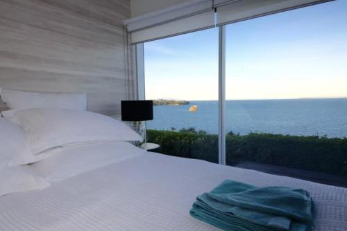 旺阿帕劳阿Luxury house with Clifftop Seaview的一间卧室设有一张床,享有海景