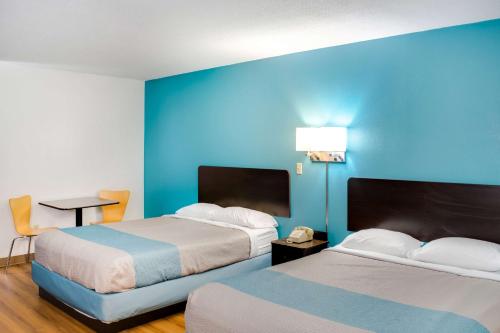 里士满Motel 6-Richmond, IN的酒店客房设有两张床和蓝色的墙壁。