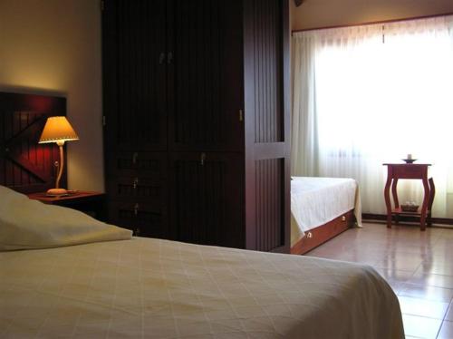 圣佩德罗Hotel Los Pinares的一间卧室设有一张床、一个窗口和一张桌子