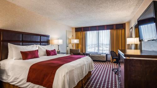 南旧金山贝斯特韦斯特普拉斯格鲁维诺酒店的酒店客房设有一张大床和一张书桌。