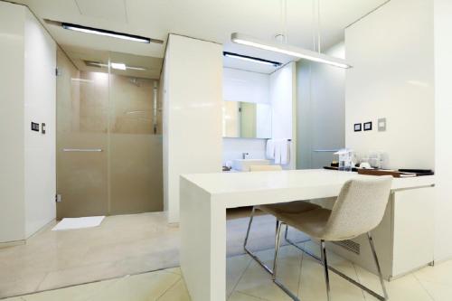 首尔宾塔经典500行政公寓的白色的厨房配有白色的桌子和椅子