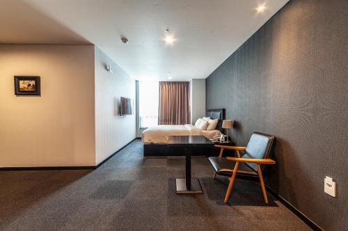江陵市江陵旅游饭店的配有一张床和一把椅子的酒店客房