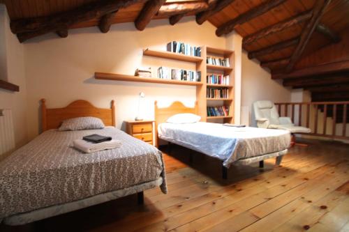 Mas de RibafetaH4, Bordes d'Arinsal, Triplex Rustico con chimenea, Arinsal, Zona vallnord的一间卧室设有两张床和书架