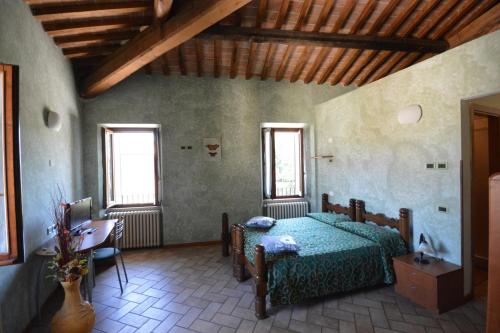 斯波莱托Ostello Villa Redenta的一间卧室配有一张床、一张桌子和两个窗户
