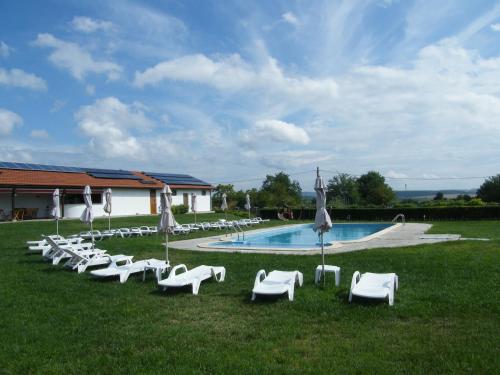 Elkhovo卢米卡伊克森特旅馆的一组白色草坪椅和一个游泳池