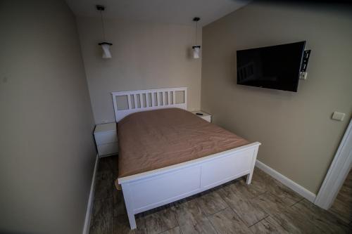 克莱佩达Mieterlux 22的一间小卧室,配有一张床和一台平面电视