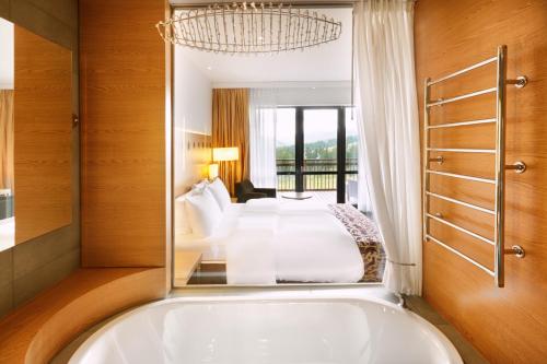 布克维比克维尔丽笙布鲁度假酒店的卧室内设有一个大浴缸