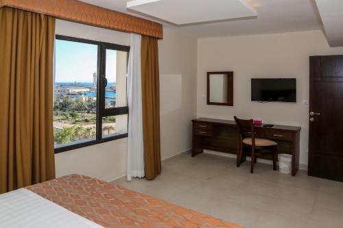 亚喀巴City Tower Hotel的酒店客房设有书桌和窗户。