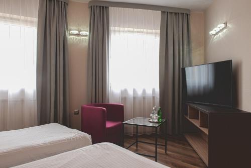 克拉科夫Hotel Major Budget的配有电视、床和椅子的酒店客房