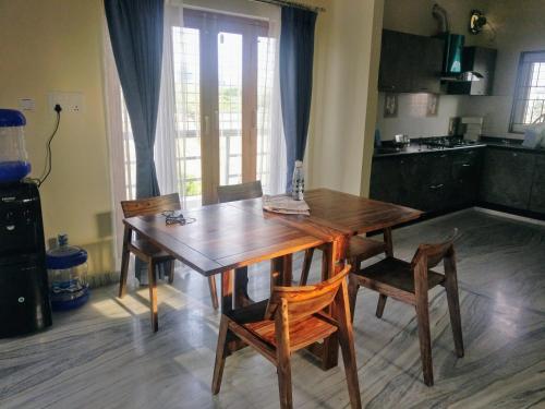 海得拉巴Misty Lake Guest House的带木桌和椅子的厨房以及带窗户的厨房。
