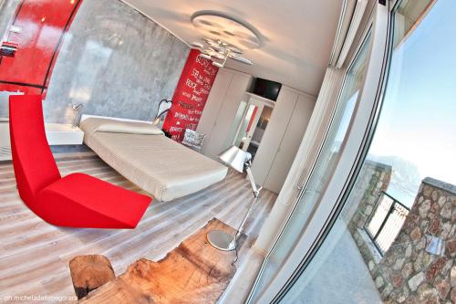托里德尔贝纳科拜亚代皮尼酒店的小房间设有一张床和一把红色椅子