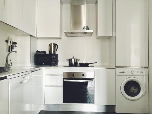 阿利坎特New apartment in San Juan Playa, Alicante的白色的厨房配有炉灶和洗衣机。