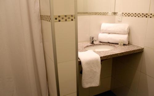 蒙得维的亚拉加托旅社蒙得维的亚旅馆的浴室配有盥洗盆、镜子和毛巾
