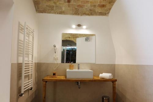 马泰拉L' Abbraccio dei Sassi的一间带水槽和镜子的浴室