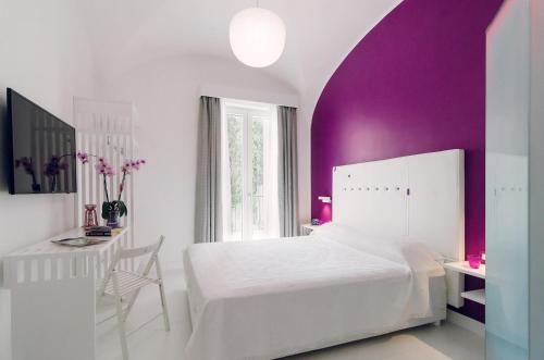 拉维罗Ravello In的卧室配有白色的床和紫色墙壁