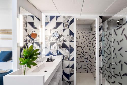 圣苏珊娜AQUA Hotel Onabrava & Spa 4*Sup的浴室的墙壁上铺有蓝色和白色的瓷砖。